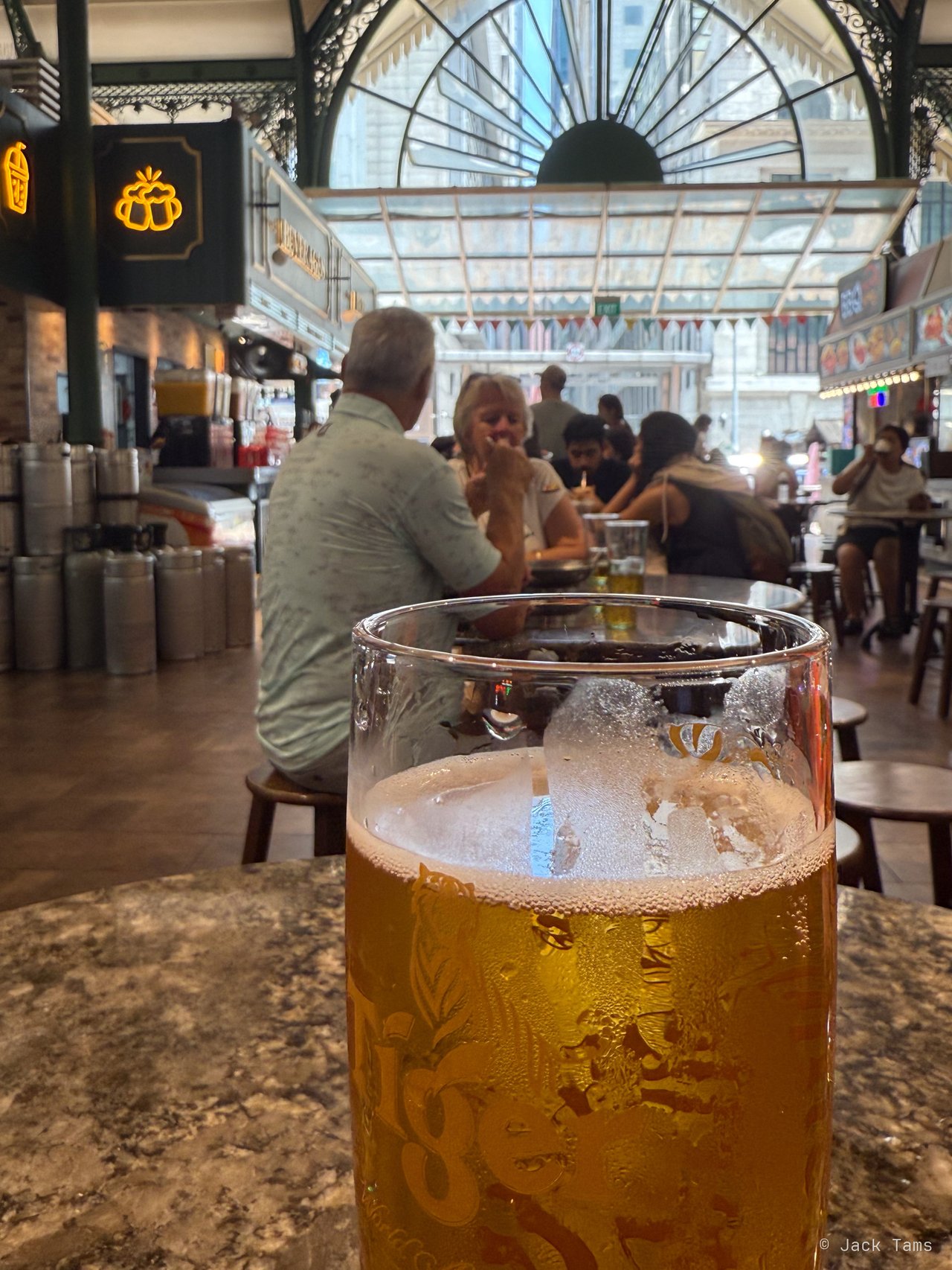 A cold beer under Lau Pa Sat's ironwork.