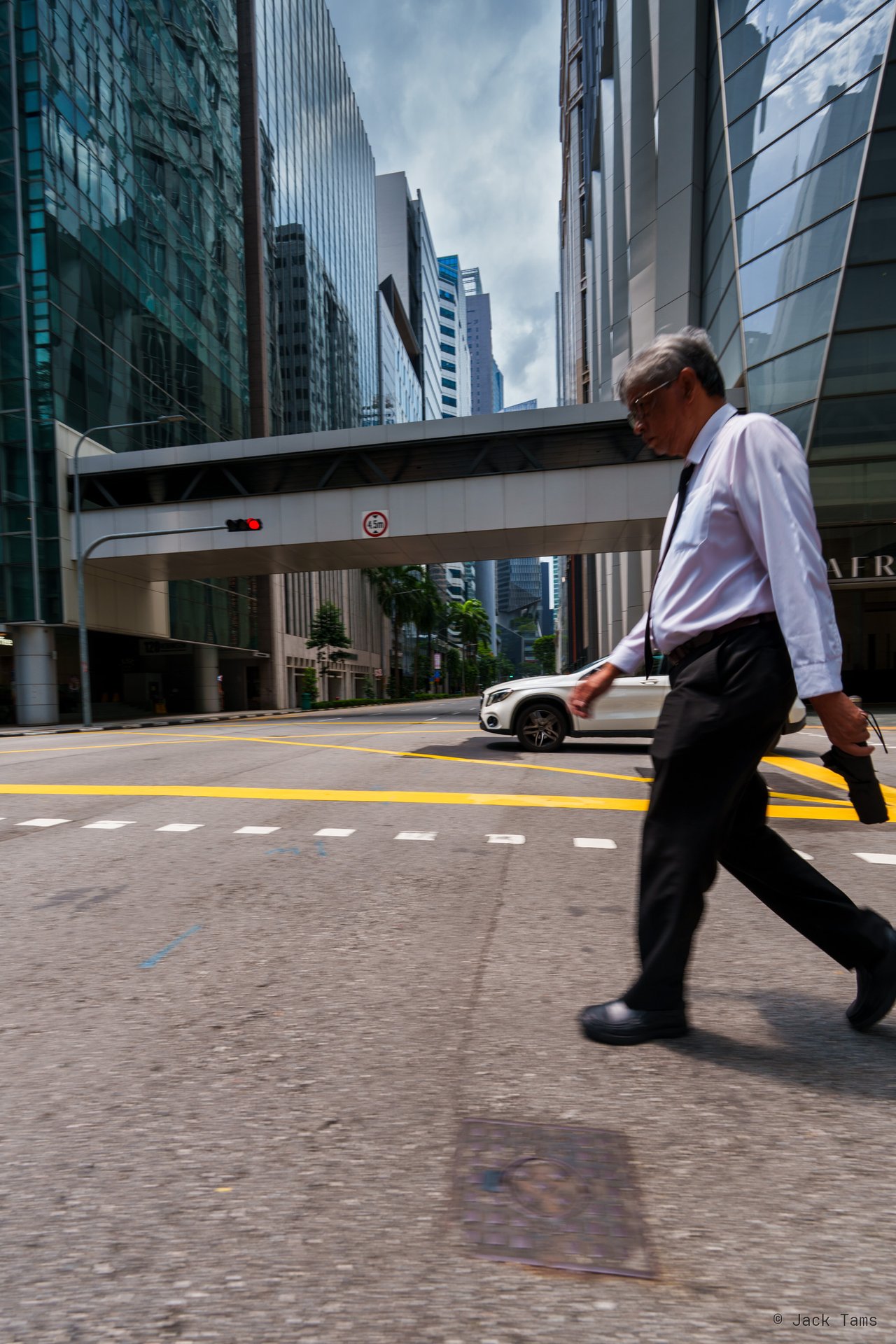 A man striding across the street in the CBD.