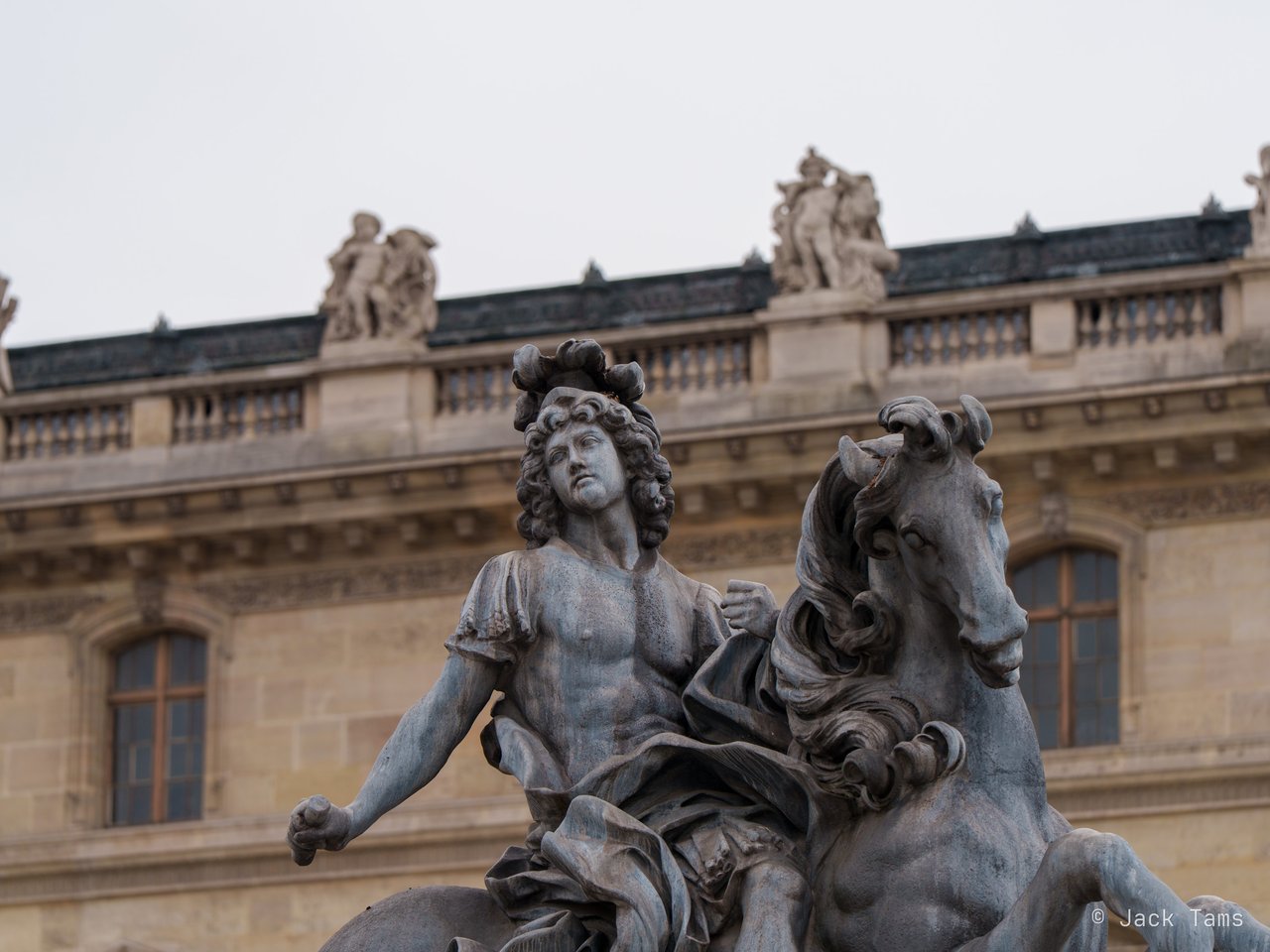An equestrian statue against the Louvre's façade.