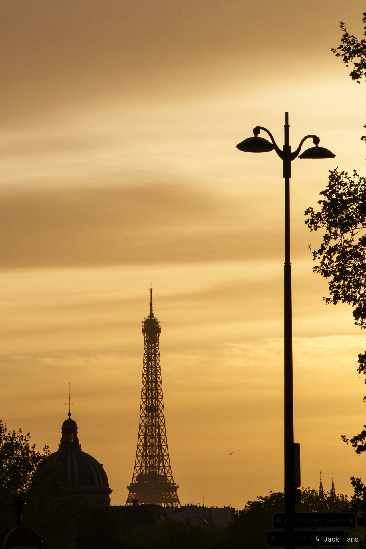 The Eiffel Tower silhouetted against a golden sky.