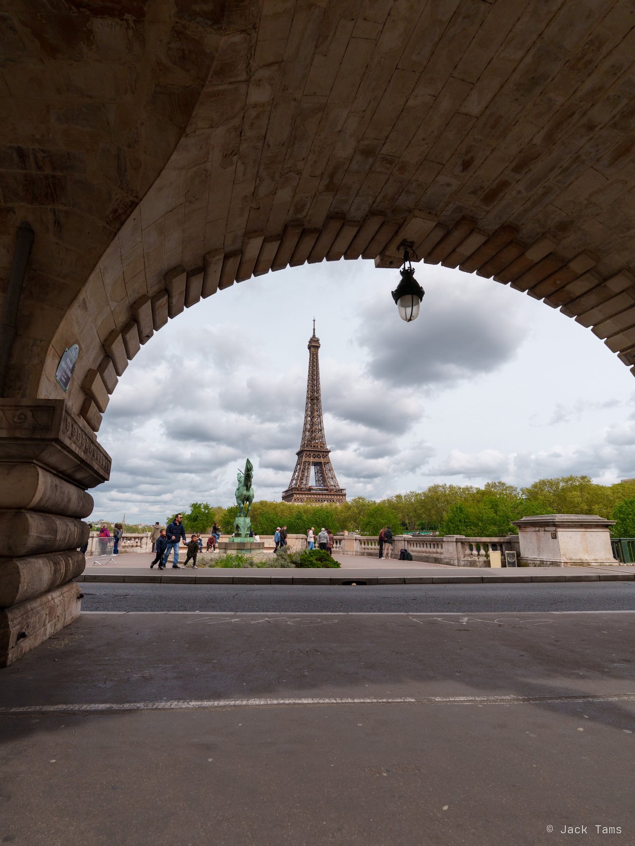 The Eiffel Tower framed by an arch of the Bir-Hakeim bridge.