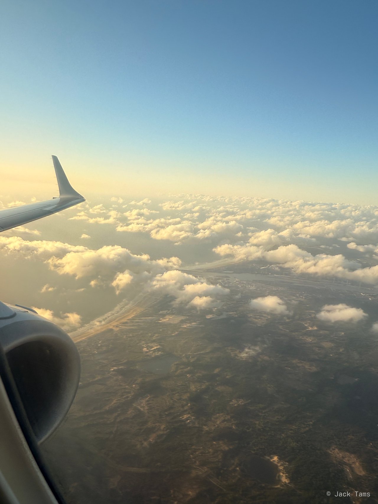 The E190's wingtip over the evening cloud.