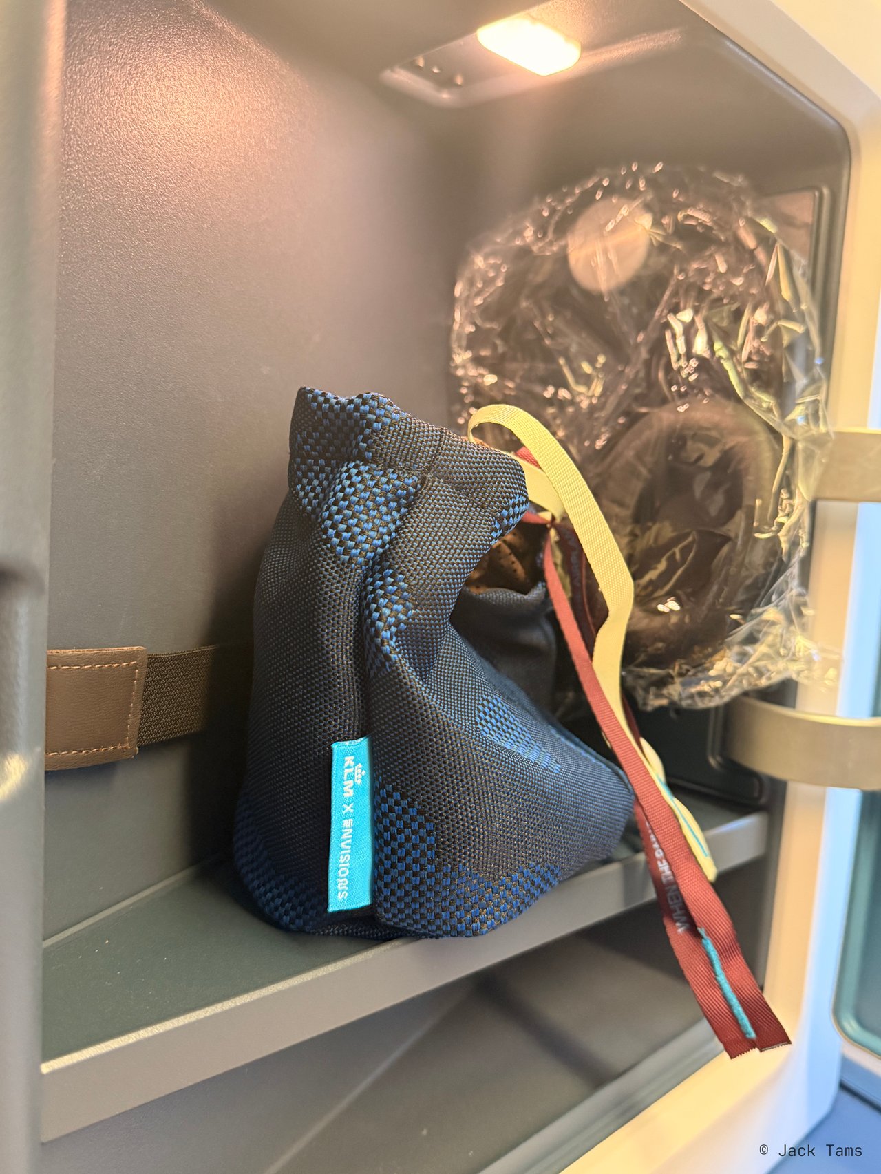 The amenity kit and headphones in the side cubby.