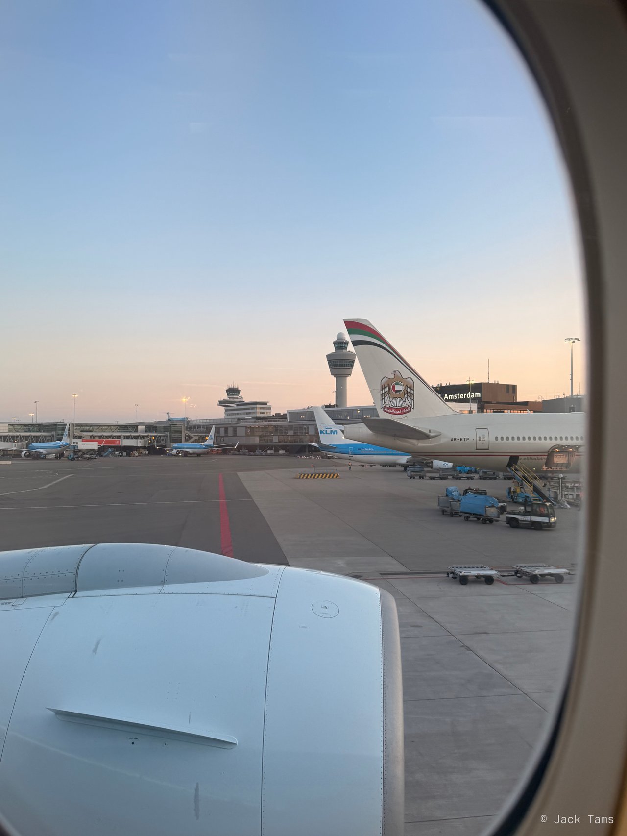 Etihad's Boeing 777-300ER A6-ETP at the next stand, a KLM 737 beyond it and the Schiphol tower.