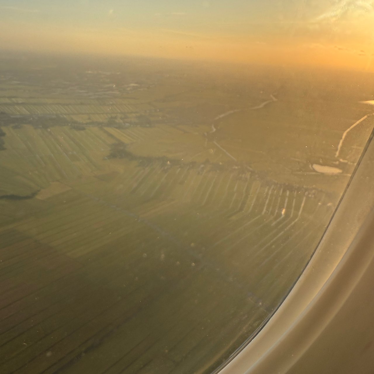 Low golden light over the polders on the approach to Schiphol.