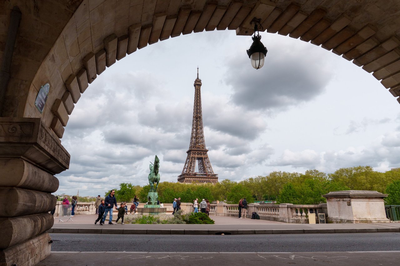 The Eiffel Tower framed by an arch of the Bir-Hakeim bridge.